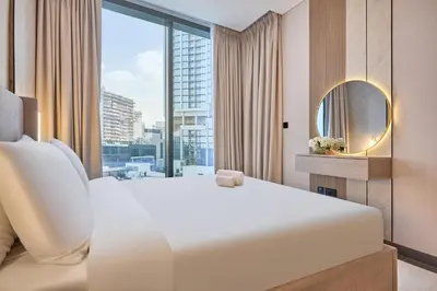 a bedroom with a large white bed and a large window at STAY BY LATINEM Luxury 1BR Holiday Home CA 0906 Near Burj Khalifa in Dubai