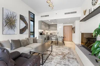 a living room with a couch and a table at Sleek Cozy Apartments in Meydan in Dubai