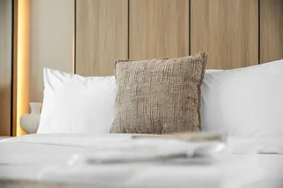 a bed with white pillows and a pillow at Serene 2BR Burj View DT Dubai in Dubai