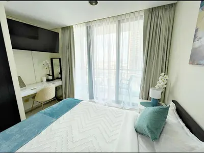 a bedroom with a bed and a desk and a window at The Minimalist JLT Studio in Dubai