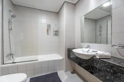 a bathroom with a sink and a tub and a toilet at GuestReady - Canal View Stay in Business Bay in Dubai