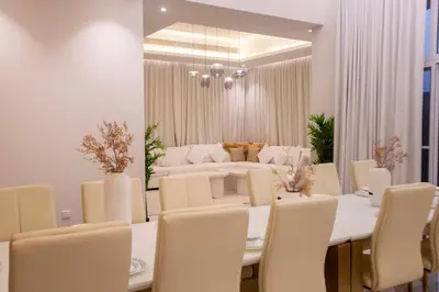 a dining room with a table and chairs and a couch at Luxury 5 Bedroom Villa Nad Al Sheba in Dubai