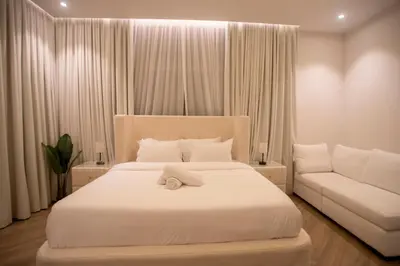 a bedroom with a white bed and a couch at Luxury 5 Bedroom Villa Nad Al Sheba in Dubai