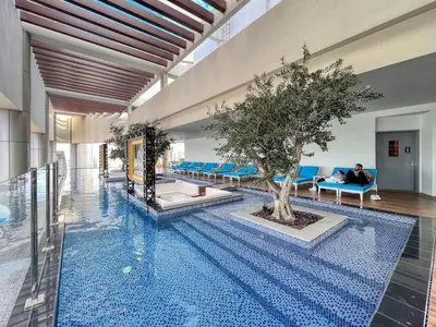 a pool with a tree in the middle of a building at Luxe 3BR in Paramount with Ocean View & Infinity Pool in Dubai