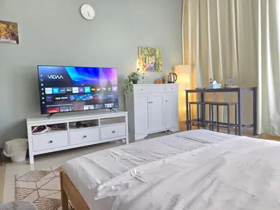 a bedroom with a bed and a flat screen tv at Chic studio in Central Dubai in Dubai