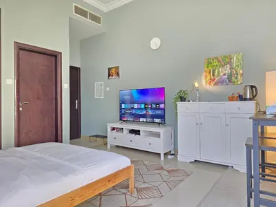 a bedroom with a bed and a flat screen tv at Chic studio in Central Dubai in Dubai