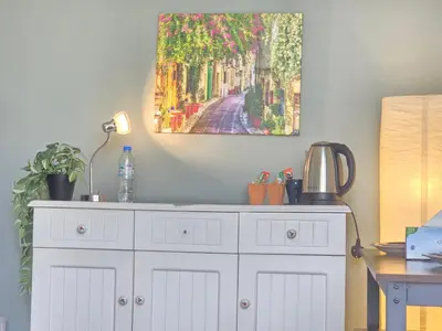 a painting hanging on a wall above a white dresser at Chic studio in Central Dubai in Dubai