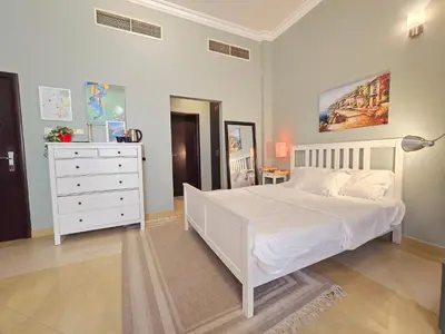 a bedroom with a white bed and a dresser at Airy and Bright Near DIFC and the Subway in Dubai
