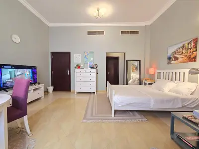 a bedroom with a white bed and a tv at Airy and Bright Near DIFC and the Subway in Dubai