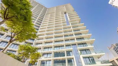 a tall white building with trees in front of it at Escape24 Brand New 1BR with City View near Burj Khalifa in Dubai
