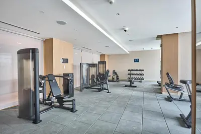 a gym with treadmills and chairs in a room at STAY BY LATINEM Luxury 1BR Holiday Home CA 1506 Near Burj Khalifa in Dubai