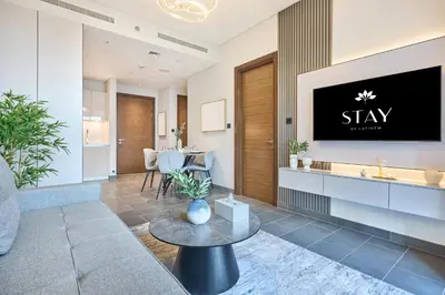 a living room with a tv on a wall at STAY BY LATINEM Luxury 1BR Holiday Home CA 1506 Near Burj Khalifa in Dubai