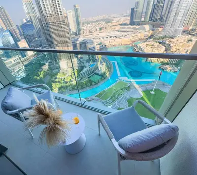 a balcony with two chairs and a view of a city at GRANDE RESIDENCES with a direct Burj Khalifa view and Private Fountain Show at 62nd floor with DXB AIRPORT VIP Shuttle option for 8 guests in Dubai
