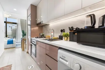 a kitchen with white countertops and a large window at Cozy Luxe Studios in Meydan in Dubai