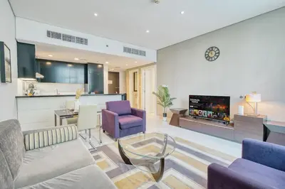 a living room with a couch and chairs and a fireplace at PVH - Refined 1BR in Business Bay - Cour Jardin in Dubai