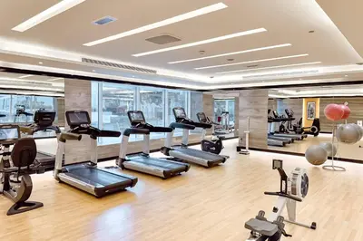 a gym with treadmills and elliptical machines at PVH - Refined 1BR in Business Bay - Cour Jardin in Dubai