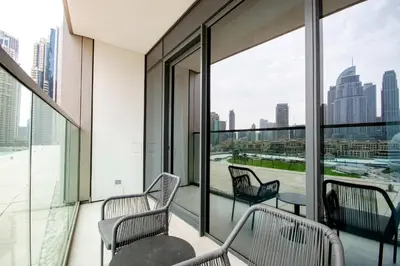 a balcony with two chairs and a table and windows at TRPS - Grande, Downtown - Full Burj Khalifa View, Luxury Furnished - Close to Dubai Mall in Dubai