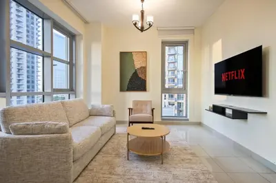 a living room with a couch and a tv at Stylish 1BR in Downtown - 5 Min to Burj & Mall in Dubai