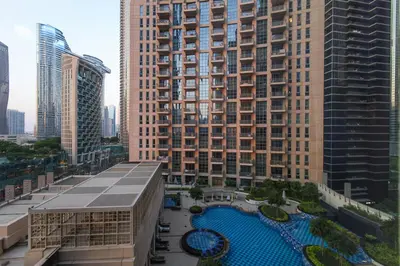 a large building with a pool in front of it at Stylish 1BR in Downtown - 5 Min to Burj & Mall in Dubai