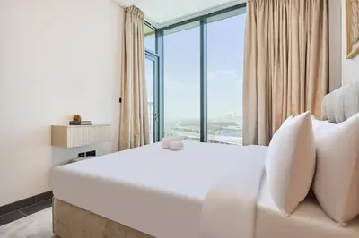 a hotel room with a white bed and a large window at STAY BY LATINEM Luxury 1BR Holiday Home CA 1509 Near Downtown in Dubai