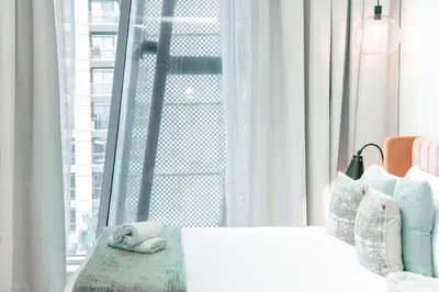 a bedroom with a white bed and a window at Stylish Stay with Rooftop Pool and Gym, Close to Dubai's Top Sights in Dubai