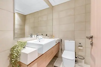 a bathroom with a white sink and a toilet at Elite Apartments in Meydan in Dubai