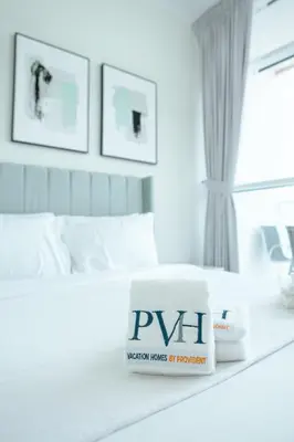 a white bedroom with a bed with a book on it at PVH - Serene Studio with Skyline View - Carson B in Dubai