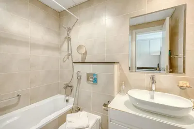 a bathroom with a sink and a tub and a mirror at PVH - Serene Studio with Skyline View - Carson B in Dubai