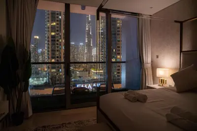 a bedroom with a large window with a view of a city at Luxury 1 BR At The Sterling in Dubai