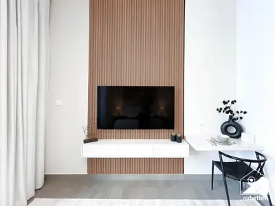 a living room with a flat screen tv on a wall at Comfort Studio in Meydan With Gym, Pool & Parking in Dubai