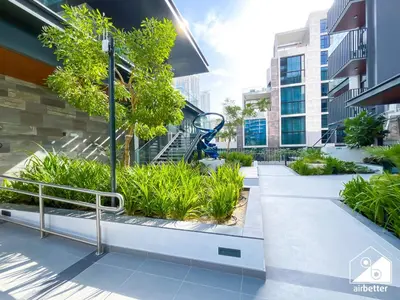 a walkway in front of a building with plants at Comfort Studio in Meydan With Gym, Pool & Parking in Dubai