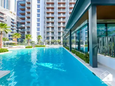a swimming pool in front of a building at Luxury Studio in Meydan With Gym, Pool Access in Dubai
