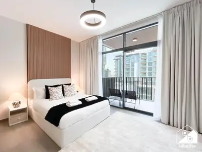a bedroom with a white bed and a large window at Luxury Studio in Meydan With Gym, Pool Access in Dubai