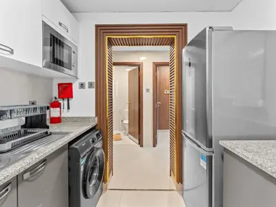 a kitchen with a washer and dryer at BLVD - Scenic View Stay with Pool and Gym Access in Dubai