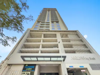 a tall white building with a blue sky in the background at BLVD - Scenic View Stay with Pool and Gym Access in Dubai