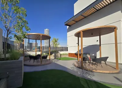 a patio with two gazebos with chairs and tables at Chic 2BR Flat in Park Lane Dubai in Dubai