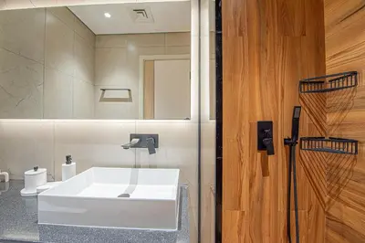 a bathroom with a white sink and a mirror at Chic 2BR Flat in Park Lane Dubai in Dubai