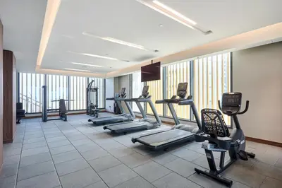 a gym with treadmills and machines in a room at STAY BY LATINEM Luxury 1BR Holiday Home CB 3607 Near Burj Khalifa in Dubai