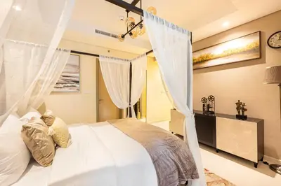 a bedroom with a white bed with curtains at Fabulous 2 BR - Paramount Midtown in Dubai