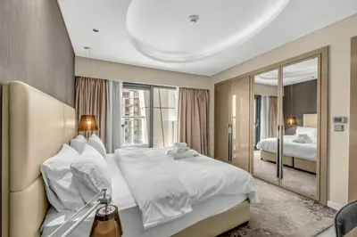 a hotel room with a large bed and a mirror at 2BR Midtown Gem - Luxurious Apartment with Balcony in Dubai