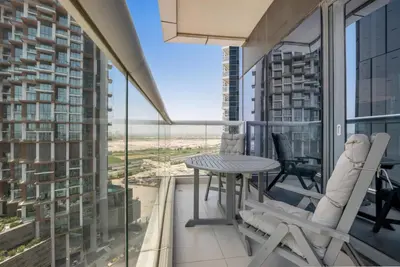 a balcony with a table and chairs and a view at 2BR Midtown Gem - Luxurious Apartment with Balcony in Dubai