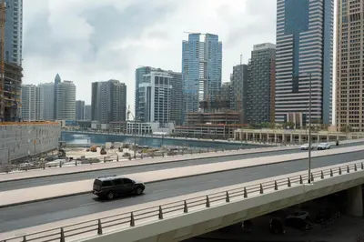 a car driving on a highway in a city at KeyRock - Modern 1BR in Zada with Pool & View in Dubai