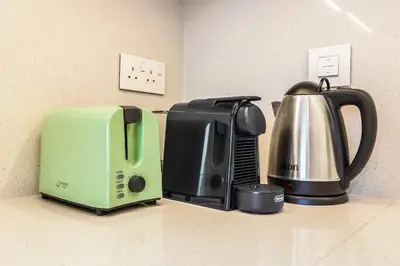 a kitchen counter with a coffee maker and a toaster at Luxury Skyline View 1BR with Pool, Gym, Parking, Concierge & Near Metro in Dubai