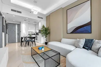 a living room with a white couch and a table at Tranquil 1BR Prime Arjan in Dubai
