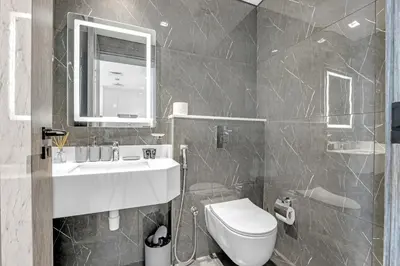 a bathroom with a sink and a toilet and a mirror at Tranquil 1BR Prime Arjan in Dubai