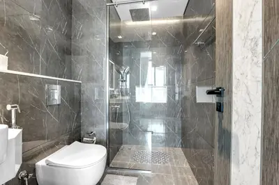 a bathroom with a toilet and a glass shower at Tranquil 1BR Prime Arjan in Dubai
