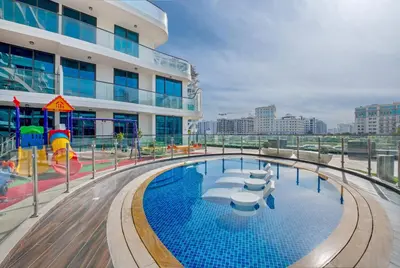 a pool on the top of a building with a playground at Tranquil 1BR Prime Arjan in Dubai