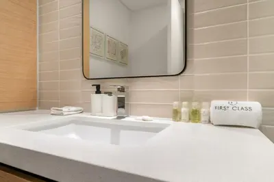 a white sink in a bathroom with a mirror at Prime 2BR Retreat, Creek Harbour Views & Comfort Near Restaurants in Dubai