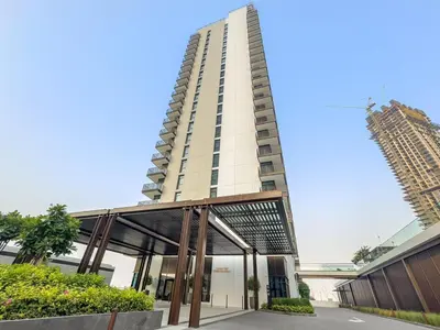 a tall white building with a glass walkway in front of it at Prime 2BR Retreat, Creek Harbour Views & Comfort Near Restaurants in Dubai