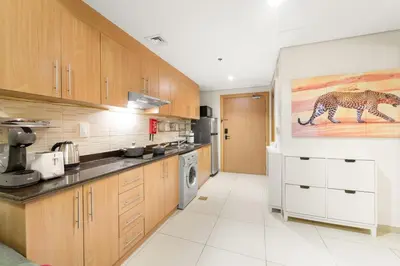 a kitchen with a cheetah painting on the wall at Dubai 1BR Balcony Views Near Miracle Garden in Dubai